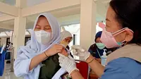 Seorang siswi SMA di Kota Palu mendapat suntikan dosis pertama vaksin di gerai vaksinasi TNI dan Dinkes Sulteng di halaman Kantor Gubernur Sulteng, Jumat (3/9/2021). (Foto: Heri Susanto/ Liputan6.com).