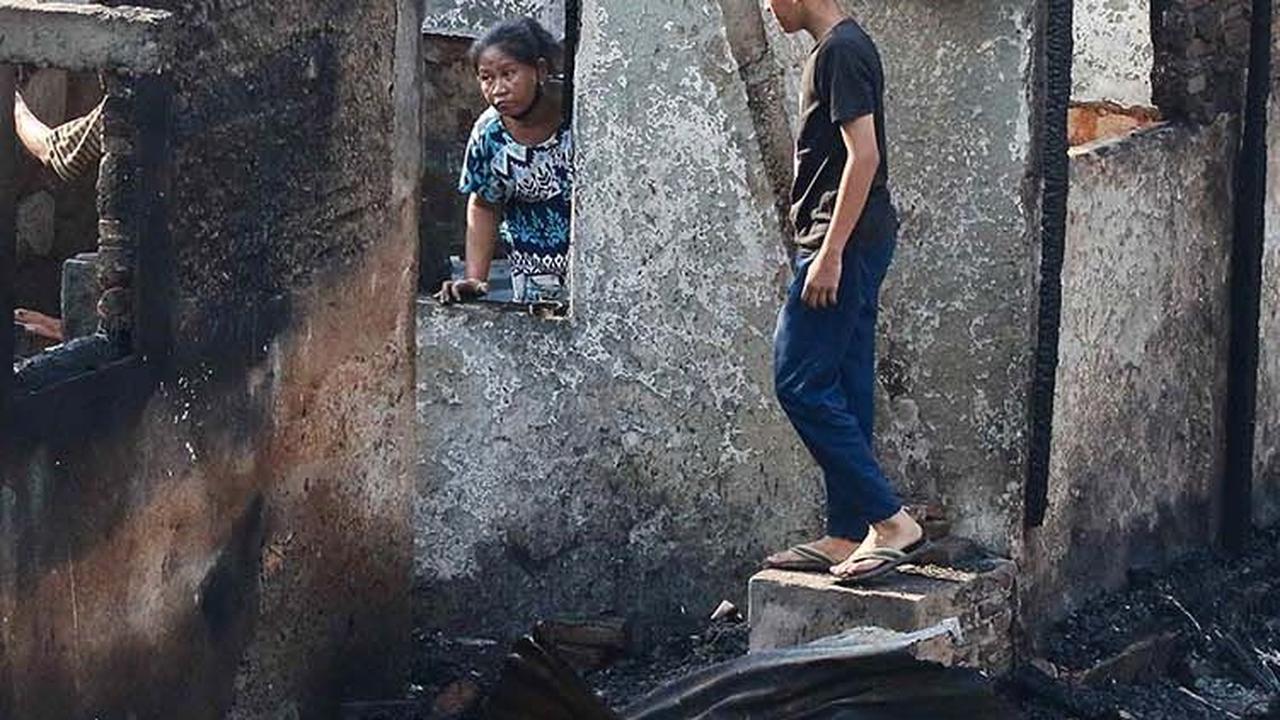 Beberapa warga kembali ke rumahnya untuk mengais barang-barang yang tersisa dari kebakaran.