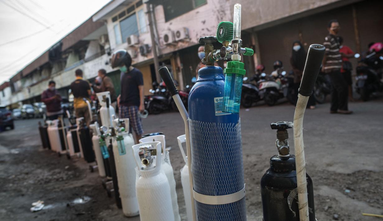 Antrean warga untuk mengisi ulang tabung oksigen di stasiun pengisian di kota Surabaya, Kamis (15/7/2021). Antrean yang terjadi di agen pengisian ulang oksigen itu disebabkan meningkatnya permintaan kebutuhan oleh warga. (Juni Kriswanto / AFP)