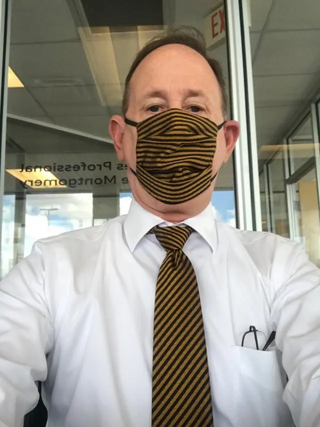 Pria kenakan motif masker dan dasi yang sama