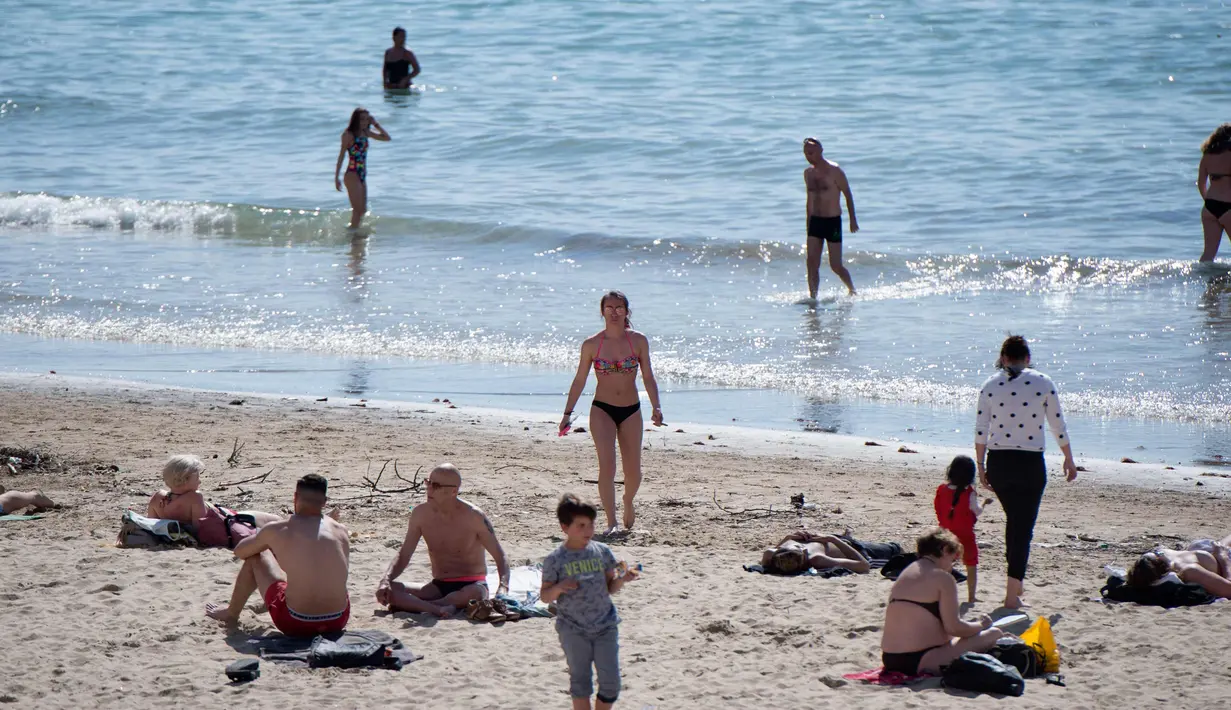 Orang-orang berjemur dan berenang di pantai Catalans (Plage des Catalans) di Marseille, Prancis Selatan, (17/4). Pantai ini memiliki dua lapangan voli pantai di mana beberapa kompetisi internasional diselenggarakan. (AFP Photo/Bertrand Langlois)