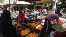 Pedagang buah melayani pembeli selama bulan suci Ramadan di pasar Baghdad (24/5/2019). Baghdad adalah salah satu kota terbesar di dunia dan menjadi rumah bagi umat Muslim, Kristiani, Yahudi dan penganut paganisme dari seluruh Timur Tengah dan Asia Tengah. (AFP Photo/Ahmad Al-Rubaye)