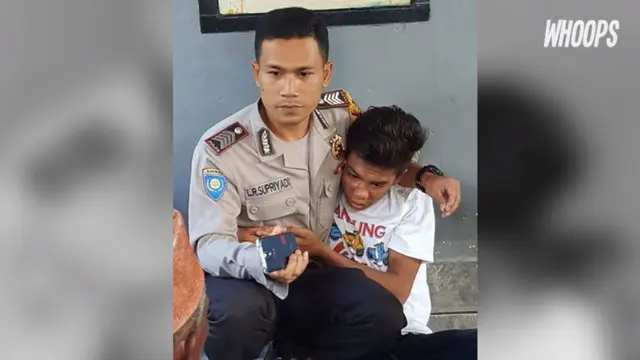 Seorang polisi berusaha menenangkan emosi warga sambil memeluk bocah yang tertangkap mencuri ayam