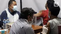 Vaksinator menyuntikan vaksin Covid-19 kepada warga di halaman Kantor Kecamatan Penjaringan, Jakarta, Kamis (19/8/2021). Vaksinasi malam ini digelar untuk menjangkau warga yang tidak bisa ikut vaksinasi pada siang hari karena bekerja dan alasan lainnya. (Liputan6.com/Helmi Fithriansyah)
