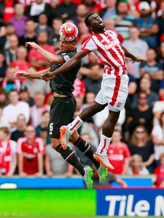 Penyerang Stoke, Mame Biram Diouf berebut bola udara dengan bek Liverpool, Dejan Lovren pada Liga Premier Inggris di Britannia Stadium, Minggu (9/8/2015).Liverpool menang atas Stoke City dengan skor 1-0. (Reuters/Jason Cairnduff)