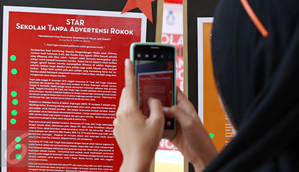 Siswa mengambil gambar poster STAR saat kegiatan 'Sekolah Tanpa Asap Rokok (STAR): Menolak Diam' di Taman Menteng, Jakarta, Sabtu (21/11). Aksi ini guna mendeklarasikan penolakan menjadi target industri rokok melalui iklan (Liputan6.com/Immanuel Antonius)