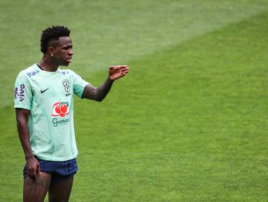 Penyerang Brasil Vinicius Junior memberi isyarat selama sesi latihan menjelang laga uji coba FIFA Matchday 2023 menghadapi Senegal, di stadion Jose Alvalade di Lisbon, Senin (19/6/2023). (Photo by CARLOS COSTA / AFP)