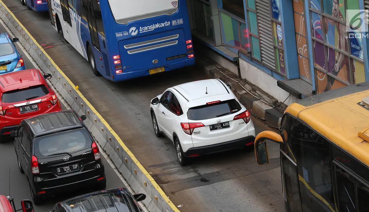 Kendaraan menerobos jalur transjakarta menghindari macet di Jalan MH Thamrin, Jakarta, Kamis (31/5). Tingginya antusiasme warga untuk berbuka puasa di rumah menyebabkan jalan-jalan protokol di Ibukota dipadati kendaraan. (Liputan6.com/Immanuel Antonius)