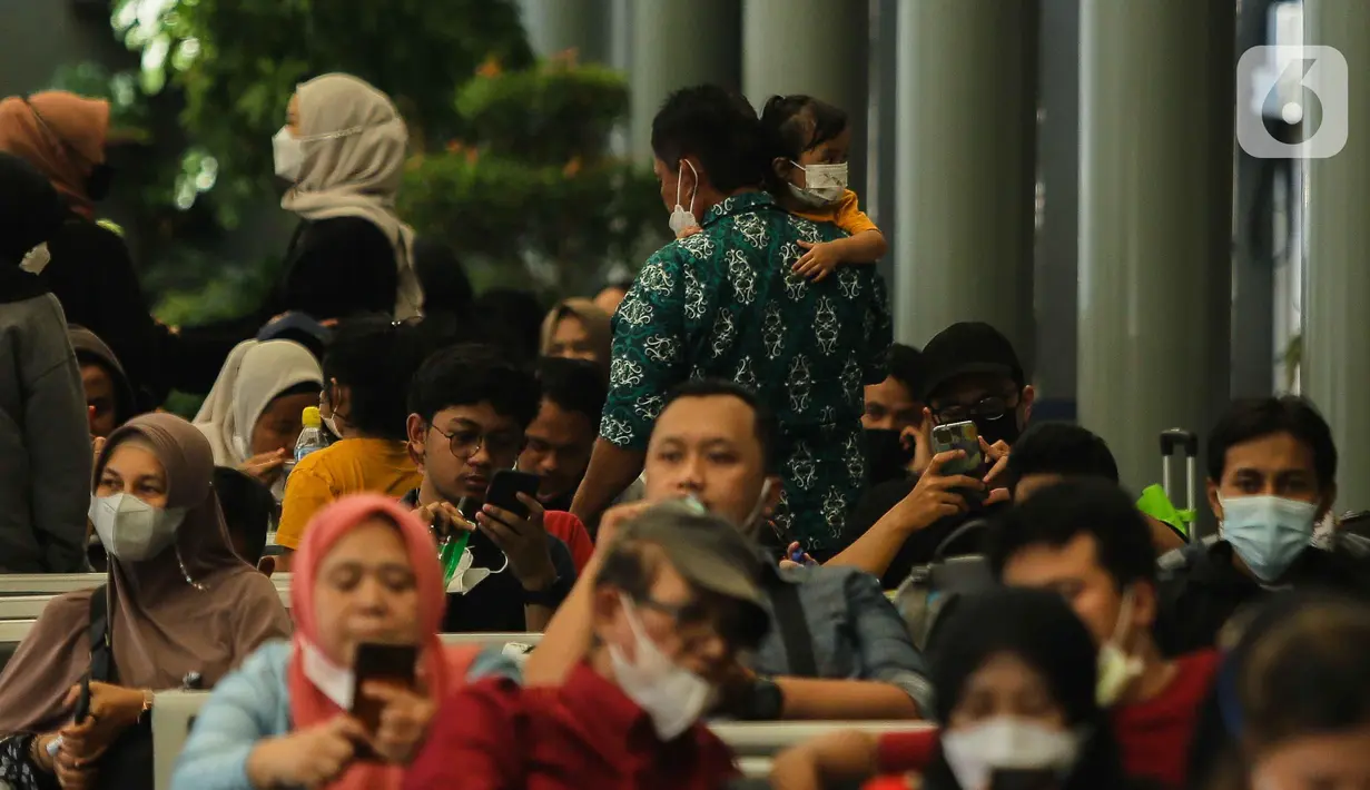 Calon penumpang menggendong anaknya saat menunggu di Stasiun Senen, Jakarta, Sabtu (23/10/2021). PT Kereta Api Indonesia (Persero) kembali memperbolehkan anak-anak usia di bawah 12 tahun naik KA Jarak jauh mulai 22 Oktober 2021. (Liputan6.com/Faizal Fanani)