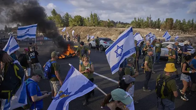 Demonstran Israel memblokir jalan saat aksi di dekat Yerusalem, Minggu (17/8/2025). Mereka menuntut pembebasan sandera dan mendesak pemerintah membatalkan keputusan mengambil alih Kota Gaza.
