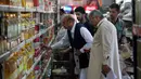 Pengunjung memilih kebutuhan pokok ketika berbelanja di supermarket yang dikelola pemerintah Pakistan di Islamabad, Rabu (16/5). Warga berbelanja memenuhi kebutuhan menyambut Puasa Ramadan yang dimulai pada Kamis (17/5). (AP/Anjum Naveed)