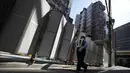 Seorang petugas keamanan mengawasi pembongkaran Nakagin Capsule Tower, bangunan ikonik yang dirancang arsitek Jepang Kisho Kurokawa pada tahun 1972, di distrik Ginza Tokyo, Selasa (12/4/2022). Pekerjaan pembongkaran menara 140 unit kapsul tersebut dimulai Selasa. (AP Photo/Eugene Hoshiko)