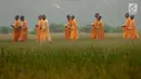 Para Bikkhu berjalan melewati area persawahan menuju Candi Blandongan saat melaksanakan prosesi Puja Waisak 2561 BE di komplek Candi Jiwa, Batujaya, Karawang, Jawa Barat (21/5). (Liputan6.com/Gempur M Surya)