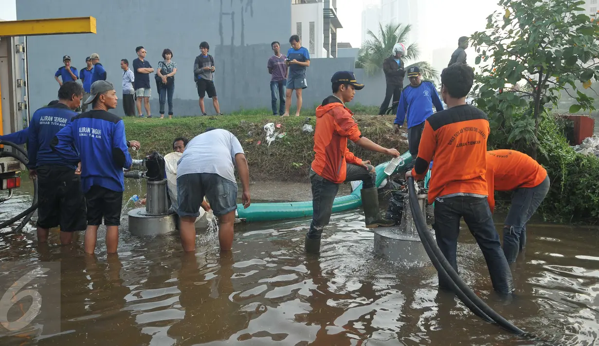 Petugas dibantu warga saat menyedot air yang menggenangi kawasan Perumahan Pantai Mutiara, Jakarta, Sabtu (4/6). Akibat tanggul jebol kawasan tersebut tergenang dengan ketinggian 50-60 sentimeter. (Liputan6.com/Gempur M Surya)