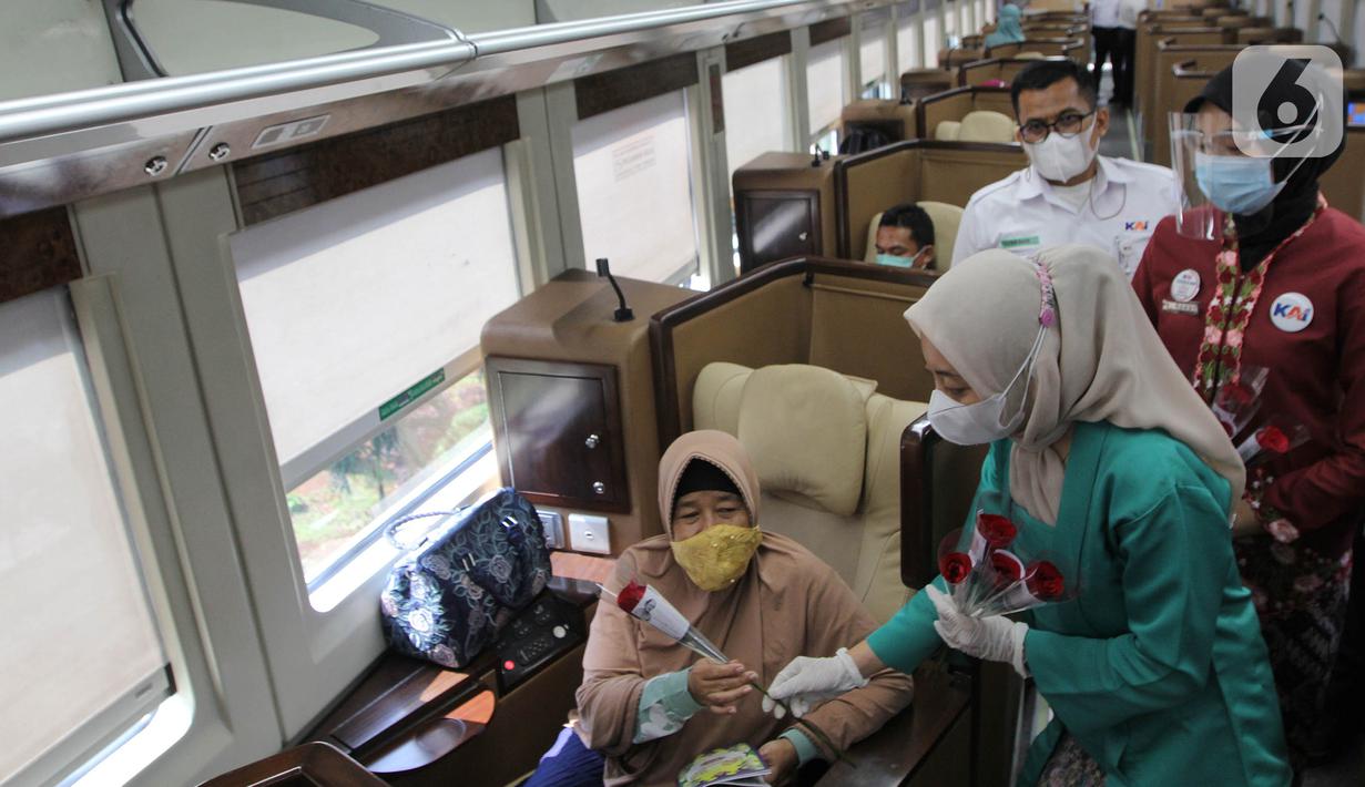 Petugas PT KAI Daop 1 Jakarta membagikan bunga kepada penumpang di Stasiun Gambir, Rabu (21/4/2021). PT KAI DAOP 1 memperingati Hari Kartini menginspirasi para penumpang agar semangat berjuang melawan pandemi COVID-19 dengan selalu menerapkan protokol kesehatan. (Liputan6.com/Herman Zakharia)
