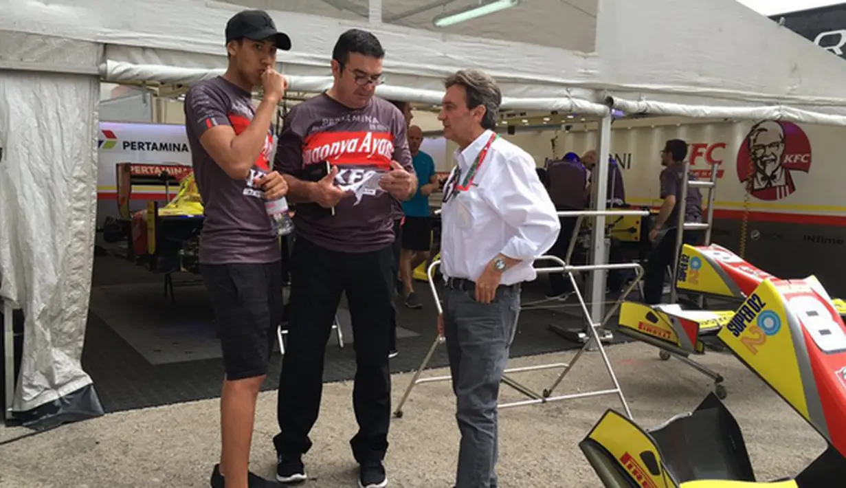 Pebalap Pertamina Campos Racing asal Indonesia, Sean Gelael, berdiskusi dengan Adrian Campos dan kru Campos Racing jelang latihan bebas GP2 Spanyol di Sirkuit Catalunya, Spanyol, Jumat (13/5/2016). (Bola.com/Twitter/TeamJagonyaAyam)
