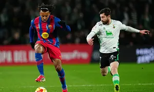 Jules Kounde berebut bola dengan Giorgi Guliashvili dalam laga babak 16 besar Copa del Rey antara Racing Santander vs Barcelona di El Sardinero, 16 Januari 2026. (AP Photo/Miguel Oses)