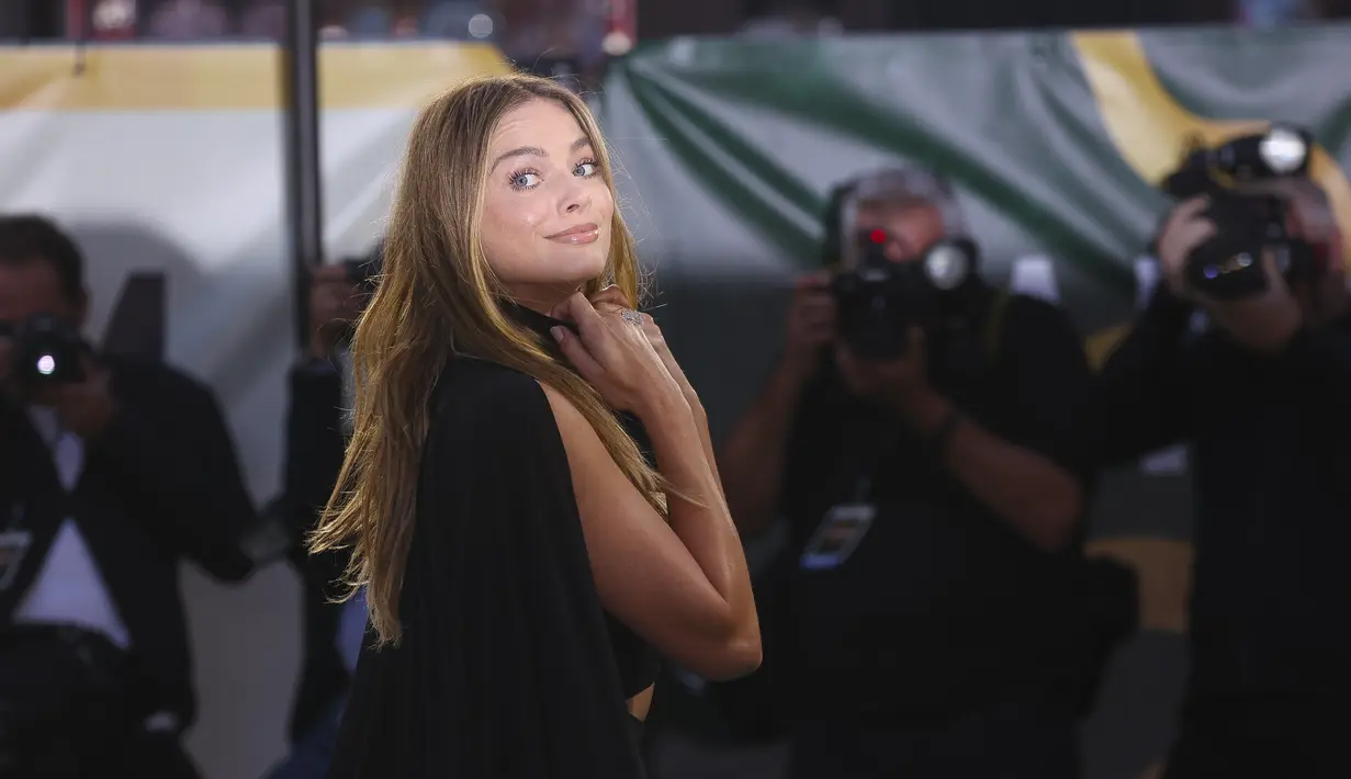 Margot Robbie berpose untuk fotografer setibanya di pemutaran perdana film 'Amsterdam' di London, Rabu, 21 September 2022.  Gaun Margot menampilkan tali spaghetti dan V-neckline yang memperlihatkan belahan dada yang cukup. (Photo by Vianney Le Caer/Invision/AP)
