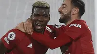 Ekspresi kegembiraan striker Manchester United, Paul Pogba (kiri) dan Bruno Fernandes, pada laga kontra Fulham di Craven Cottage, Kamis (21/1/2021). (AFP/Adrian Dennis)