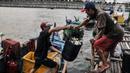 Nelayan memindahkan ikan dalam wadah di kawasan pesisir Kalibaru, Cilincing, Jakarta Utara, Senin (19/9/2022). Para nelayan di kawasan Cilincing mengeluhkan kebijakan pemerintah menaikkan harga bahan bakar minyak (BBM) bersubsidi jenis solar. (merdeka.com/Iqbal S. Nugroho)