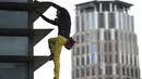 Alain Robert saat berusaha memanjat Menara Internasional GT berlantai 47 di Makati City, Manila, Filipina (29/1). Pria berusia 56 tahun itu memanjat Menara GT 47 lantai tanpa peralatan keselamatan dan menjadi tontonan warga. (AFP Photo/Ted Aljibe)