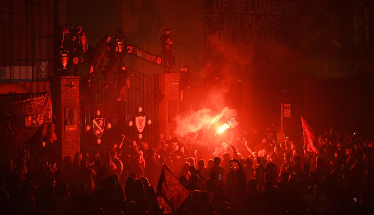 Fans Liverpool merayakan gelar juara Premier League di area Standion Anfield usai pertandingan Liverpool melawan Chelsea, Kamis (23/7/2020) dini hari WIB. Fans Liverpool tetap berdatangan ke area Stadion Anfield meski ada permintaan untuk merayakan di rumah. (AFP/Oli Scarff)