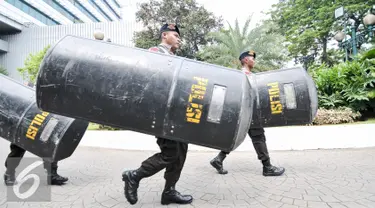 Sejumlah polisi berjalan membawa tameng setelah mengikuti apel di halaman Balai Kota, Jakarta, Jumat (4/11). Jelang demonstrasi besar-besaran pengamanan Balai Kota ditingkatkan. (Liputan6.com/Yoppy Renato)