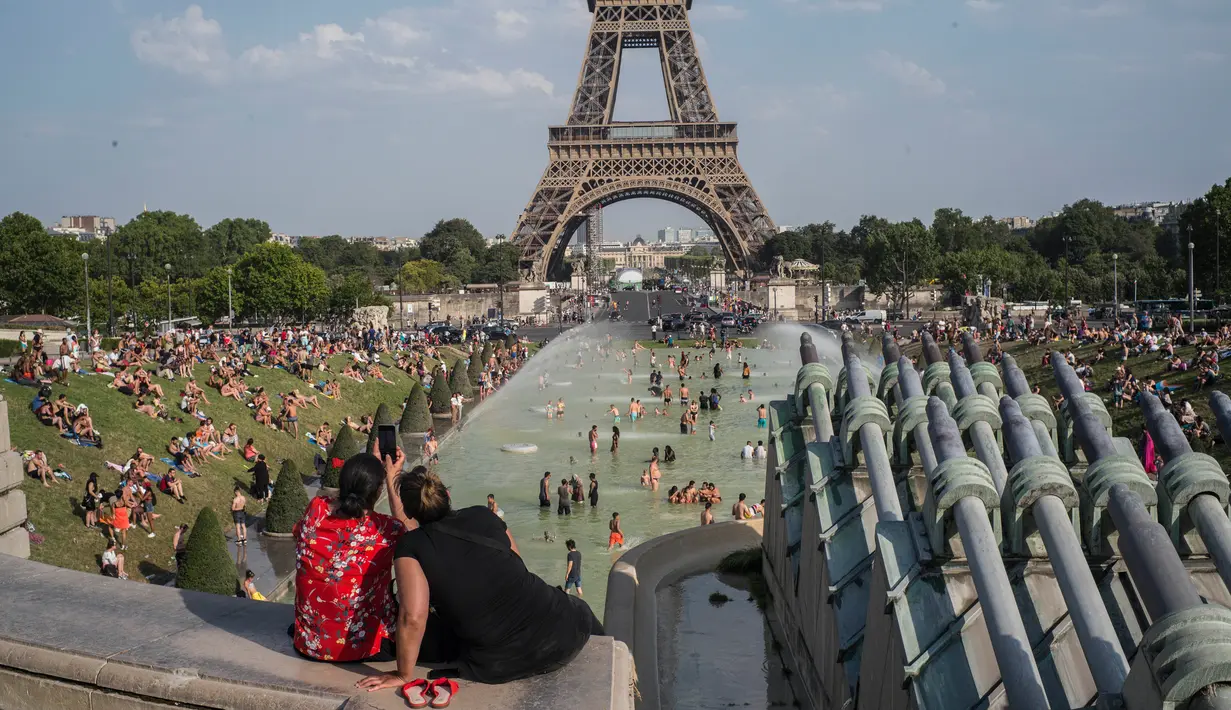 Turis dan warga menyejukkan diri dengan berendam di kolam Trocadero Fountains (air mancur Trocadero) dekat Menara Eiffel di Paris, Kamis (25/7/2019). Gelombang panas di Eropa mencapai puncaknya, bahkan suhu di ibu kota Prancis mencapai di atas 41 derajat Celcius. (AP/Rafael Yaghobzadeh)