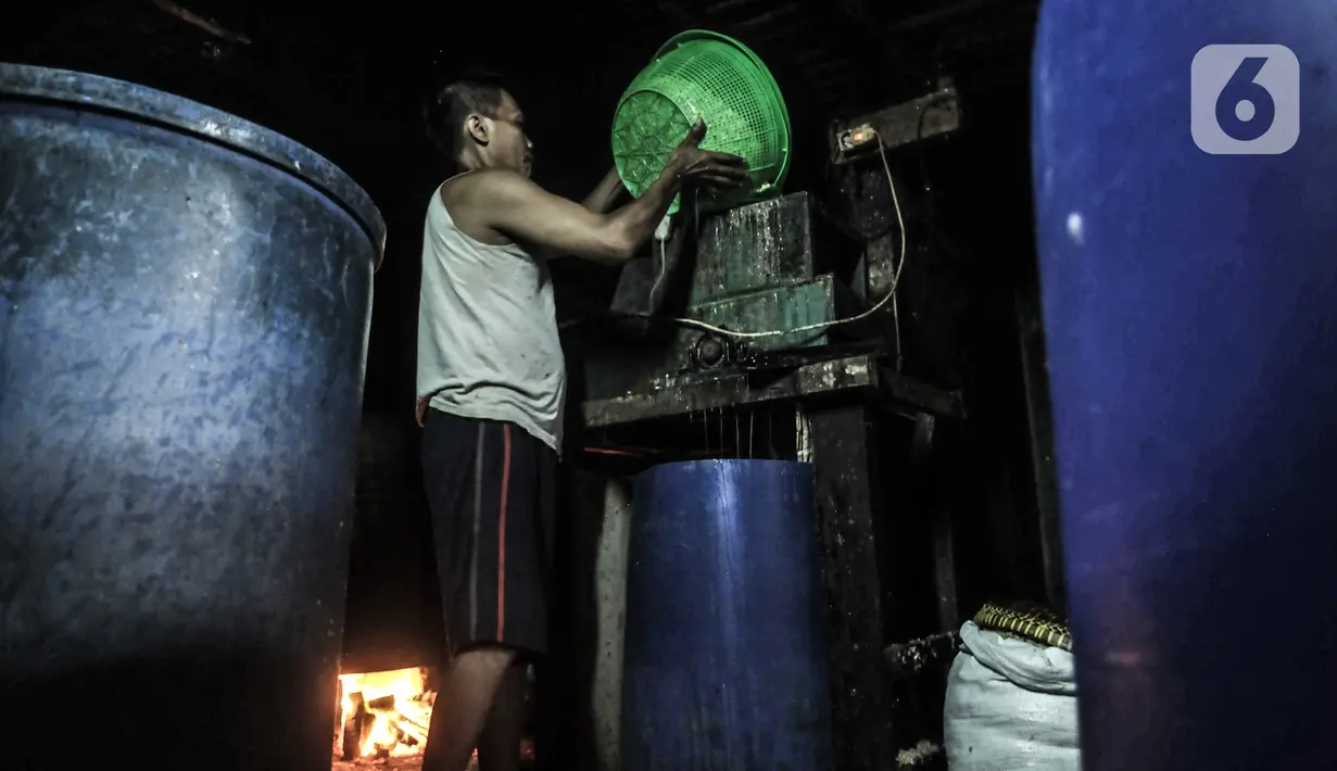 Pekerja menuang kedelai rebus saat proses pembuatan tempe di kawasan Sunter, Jakarta, Senin (4/1/2021). Perajin tempe setempat berupaya mengurangi kerugian akibat melonjaknya harga kedelai impor dengan memperkecil ukuran tempe dan menaikan harga jual. (merdeka.com/Iqbal S. Nugroho)