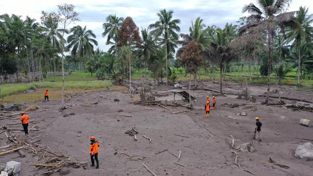 <span>Foto udara Tim SAR (oranye dan hijau) melakukan operasi pencarian orang hilang menyusul erupsi Gunung Semeru di desa Sumberwuluh, Lumajang, Jawa Timur, Senin (6/12/2021). Berdasarkan laporan BNPB, jumlah korban meninggal sampai Minggu sore berjumlah 14 orang. (ADEK BERRY/AFP)</span>