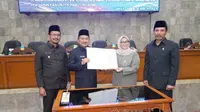 Bupati Garut Rudy Gunawan dan Ketua DPRD Euis Ida Wartiah, tengah menunjukan dokumen persiapan pembentukan DOB Garut Selatan dalam sidang paripurna (Liputan6.com/Jayadi Supriadin)