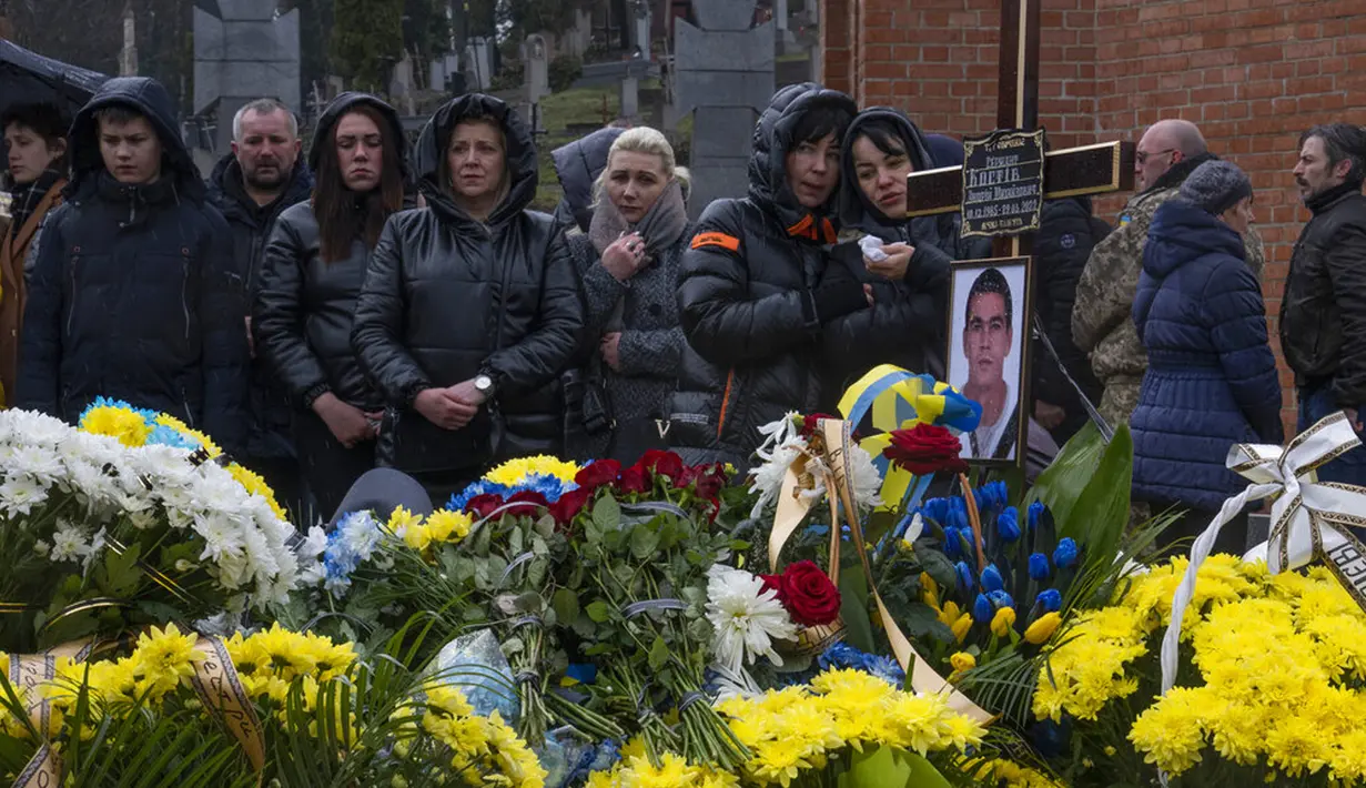 Keluarga dan teman menghadiri pemakaman Sersan Kostiv Andrew (37) yang tewas dalam perang dengan Rusia di pemakaman Lychakiv, Lviv, Ukraina, Selasa (5/4/2022). (AP Photo/Nariman El-Mofty)