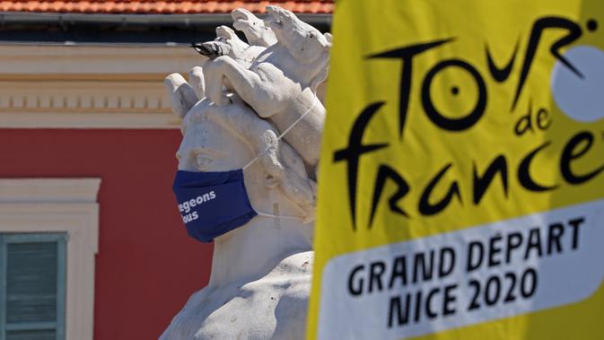 Logo Tour de France 2020 terlihat di dekat patung bermasker di kota Nice, French Riviera, Rabu (26/8/2020). Ajang balap sepeda lintas kota di Prancis kali ini akan dimulai dari kota Nice pada 29 Agustus hingga 20 September di bawah bayang-bayang 'gelombang kedua' COVID-19. (Kenzo Tribouillard/AF