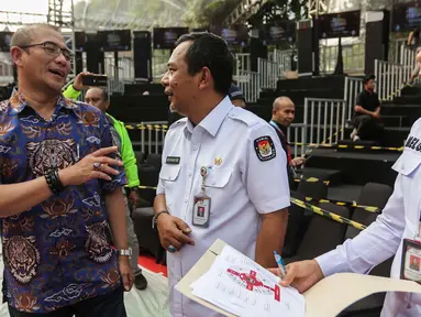 Ketua Komisi Pemilihan Umum (KPU) Hasyim Asy'ari (kiri) saat meninjau panggung debat Capres/Cawapres Pemilu 2024 di Halaman Gedung KPU, Jakarta, Senin (11/12/2023). (Liputan6.com/Angga Yuniar)