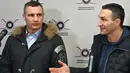 Wali Kota Kiev, Vitali Klitschko (kiri) dan saudaranya yang mantan petinju Ukraina Wladimir Klitschko berbicara kepada pers saat pembukaan pusat rekrutmen Pasukan Pertahanan Wilayah di Kiev, 2 Februari 2022. Wladimir Klitschko mendaftar menjadi tentara cadangan Ukraina. (Genya SAVILOV/AFP)