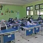 Sejumlah siswa mengikuti kegiatan belajar tatap muka di SMP Negeri 2 Bekasi, Selasa (23/3/2021). Pemerintah Kota Bekasi mengizinkan sejumlah sekolah yang berada di Zona Hijau mengadakan pembelajaran tatap muka atau PTM dengan mengikuti pedoman protocol. (Liputan6.com/Herman Zakharia)