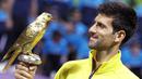 Petenis Serbia, Novak Djokovic, memegang piala usai menjadi pemenang tunggal putra Qatar Open di Doha, Minggu (10/1/2016). Pada laga final dirinya mengalahkan Rafael Nadal. (Reuters/Naseem Zeitoon)