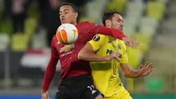 Striker Manchester United, Mason Greenwood (kiri) berebut bola dengan bek Villarreal, Alfonso Pedraza pada laga final Liga Europa 2020/2021 di Gdansk Stadium, Gdansk, Polandia (26/5/2021). Mason Greenwood total mencetak 6 gol dan 2 assist dari 18 penampilan bersama MU dalam dua edisi Liga Europa yang diikutinya pada musim 2019/2020 dan 2020/2021. (AFP/Pool/Michael Sohn)