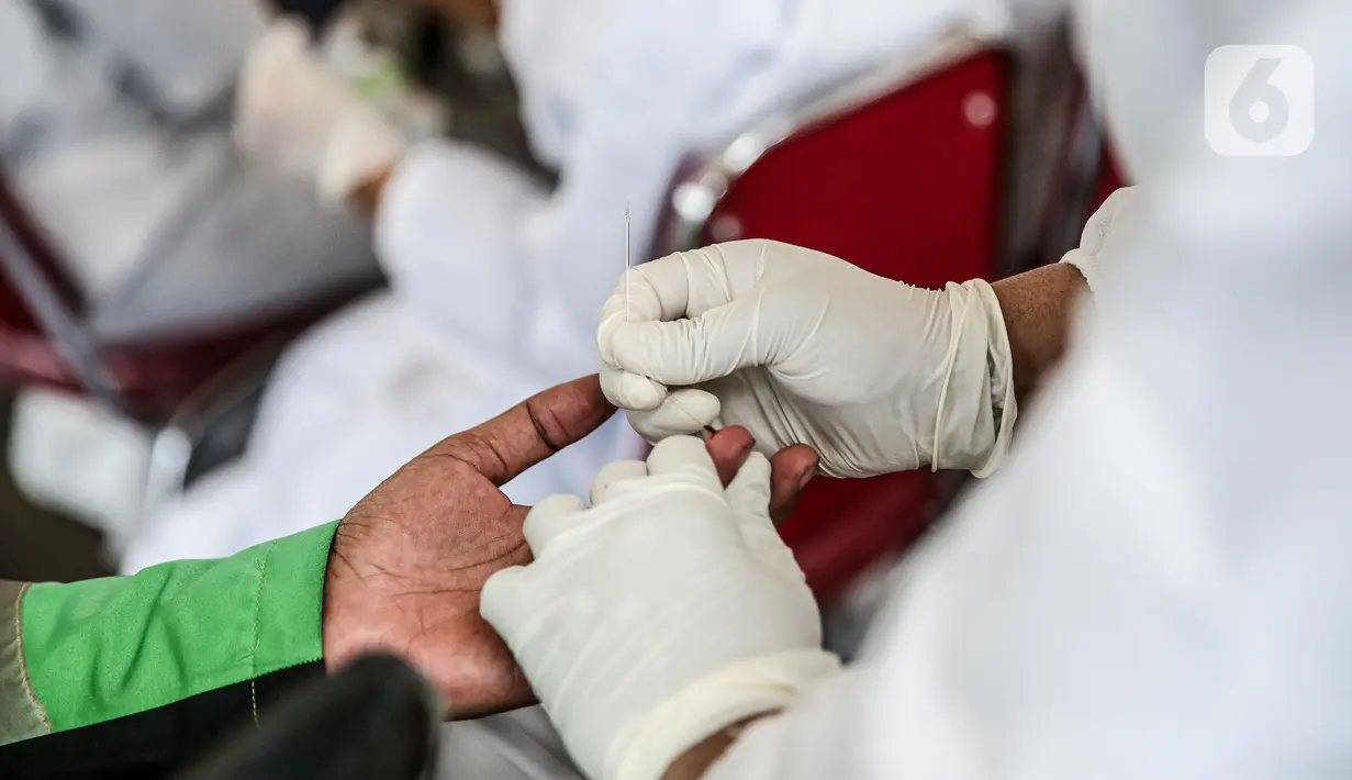 Petugas mengambil sampel darah saat tes cepat (rapid test) di depan gedung Kejaksaan Agung, Jakarta, Kamis (6/8/2020). Kejagung menggelar rapid test massal kepada warga yang melintas di kawasan itu guna memastikan kesehatannya dan mengantisipasi penyebaran COVID-19. (Liputan6.com/Faizal Fanani)