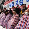 Pemilik usaha kecil dicukur rambutnya saat rapat umum menentang aturan jaga jarak dari pemerintah dekat Majelis Nasional di Seoul, Korea Selatan, 25 Januari 2022. Korea Selatan mencatat lebih dari 8.000 infeksi COVID-19 baru untuk pertama kalinya. (AP Photo/Ahn Young-joon)