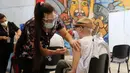 Seorang pria lansia menerima suntikan BioNtech Pfizer COVID-19 sebagai booster di Santiago, Chile, 7 Februari 2022. Di tengah gelombang COVID-19, Chile memulai vaksinasi dosis keempat untuk warga di atas usia 55 tahun. (JAVIER TORRES/AFP)