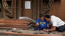 Pengrajin kayu membuat sketsa diatas kayu sebelum diukir di Lalitput, Nepal (19/7). (AP Photo/Niranjan Shrestha)