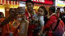 Tontowi Ahmad menggendong anak dan menlayan foto bersama fans saat tiba di Bandara Soekarno-Hatta, Cengkareng (29/8/2017). Tontowi/Liliyana meraih medali emas pada kejuaraan dunia di Glasgow. (Bola.com/Nicklas Hanoatubun)