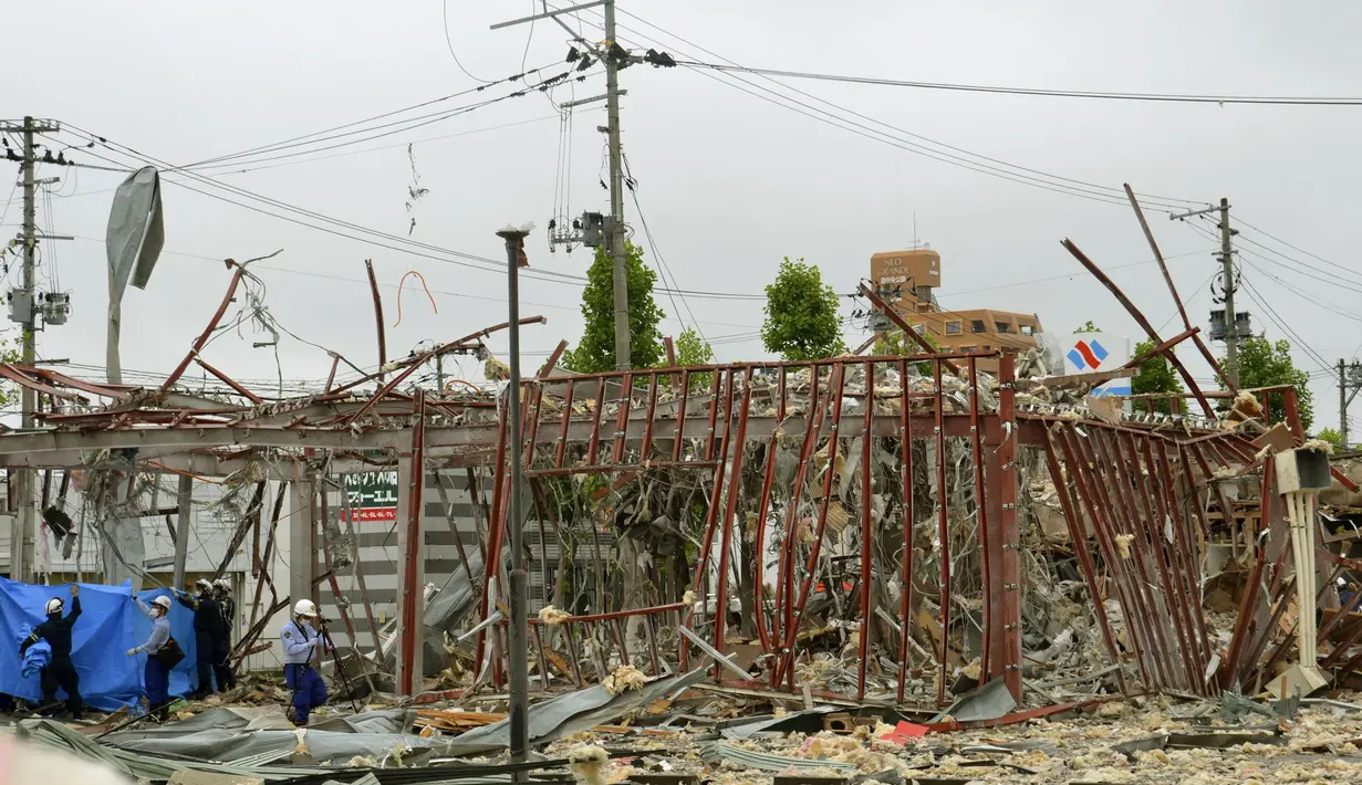 Penyelidik bekerja di lokasi ledakan di Koriyama, Prefektur Fukushima, Jepang utara, Kamis, (30/7/2020). Setidaknya lebih dari puluhan orang terluka dan dibawa ke rumah sakit setelah ledakan akibat kebocoran gas menghantam dinding, jendela, dan bangunan di lingkungan tersebut. (Berita Kyodo via AP)
