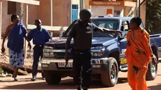 Pasukan keamanan Mali mengevakuasi dua wanita yang menjadi sandera di Hotel Radisson Blu di Bamako, Jumat (20/11). Kelompok militan Islam menyerbu hotel mewah tersebut dan  menyandera lebih dari 100 orang tamu serta staf hotel. (AFP PHOTO/Habibou Kouyate)