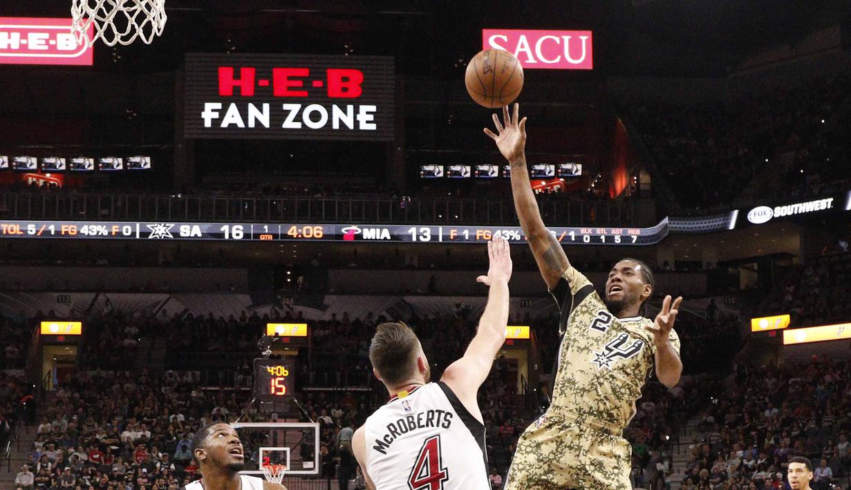 Pemain San Antonio Spurs, Kawhi Leonard (2) mengelabui pemain  Miami Heat,  Josh McRoberts (4) pada lanjutan NBA di AT&T Center, Texas, Kamis (24/3/2016). San Antonio Spurs menang 112-88. (Mandatory Credit: Soobum Im-USA TODAY Sports)