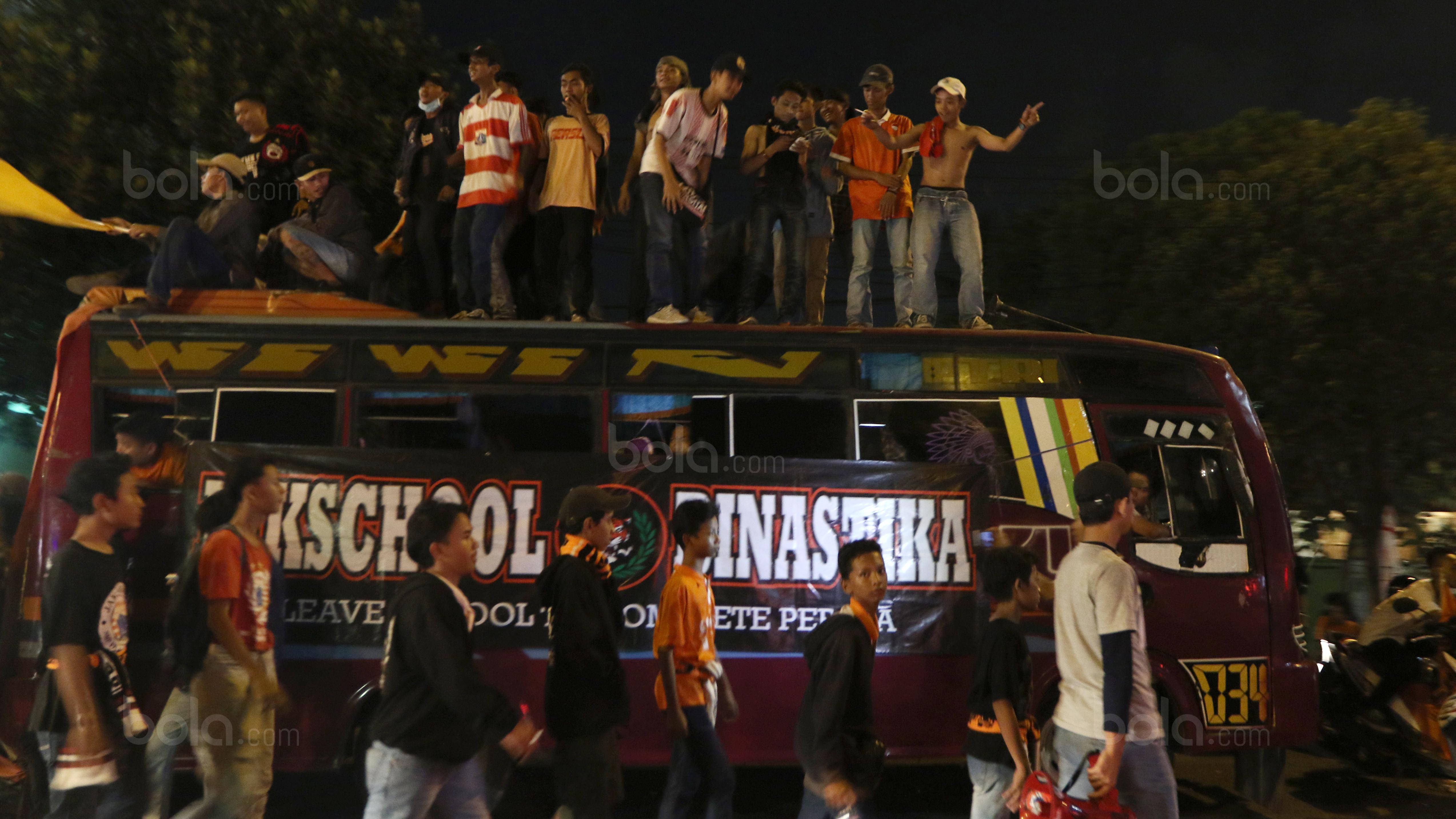 Sekelompok The Jakmania tengah bernyanyi dan menari di atas bus. (Bola.com/Nicklas Hanoatubun)