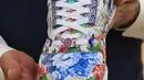 Pekerja memegang sepatu kets unik kolaborasi Adidas dan produsen porselen Meisse bernama Porcelain ZX8000, saat pratinjau di rumah lelang Sotheby di New York City pada 4 Desember 2020. Sepatu yang akan dilelang bulan ini diperkirakan terjual dengan nilai hingga 1 juta dollar AS. (Kena Betancur/AFP)