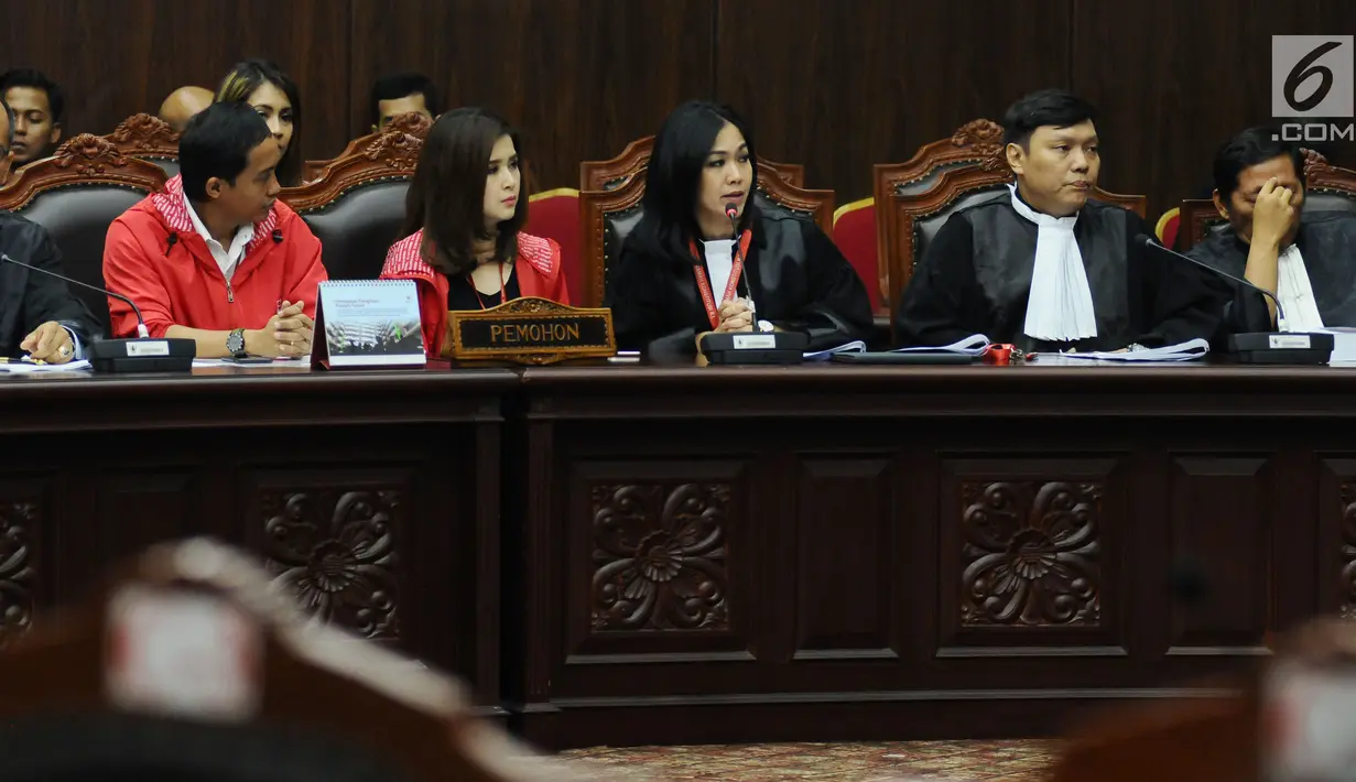 Kuasa hukum pemohon (tengah) membacakan nota saat sidang perdana permohonan uji materi UU Nomor 7 Tahun 2017 tentang Penyelenggaraan Pemilu di Gedung MK, Jakarta, Selasa (5/9). Ada tiga pasal yang diuji materikan. (Liputan6.com/Helmi Fithriansyah)