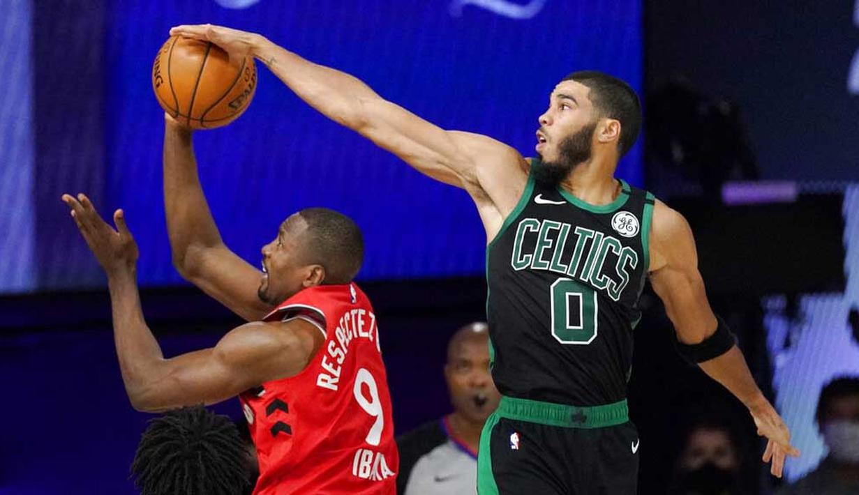 Pebasket Boston Celtics, Jayson Tatum, berebut bola dengan pebasket Toronto Raptors, Serge Ibaka, pada laga NBA di Lake Buena Vista, Senin (7/9/2020). Boston Celtics menang telak 111-89 atas Toronto Raptors. (AP/Mark J. Terrill)